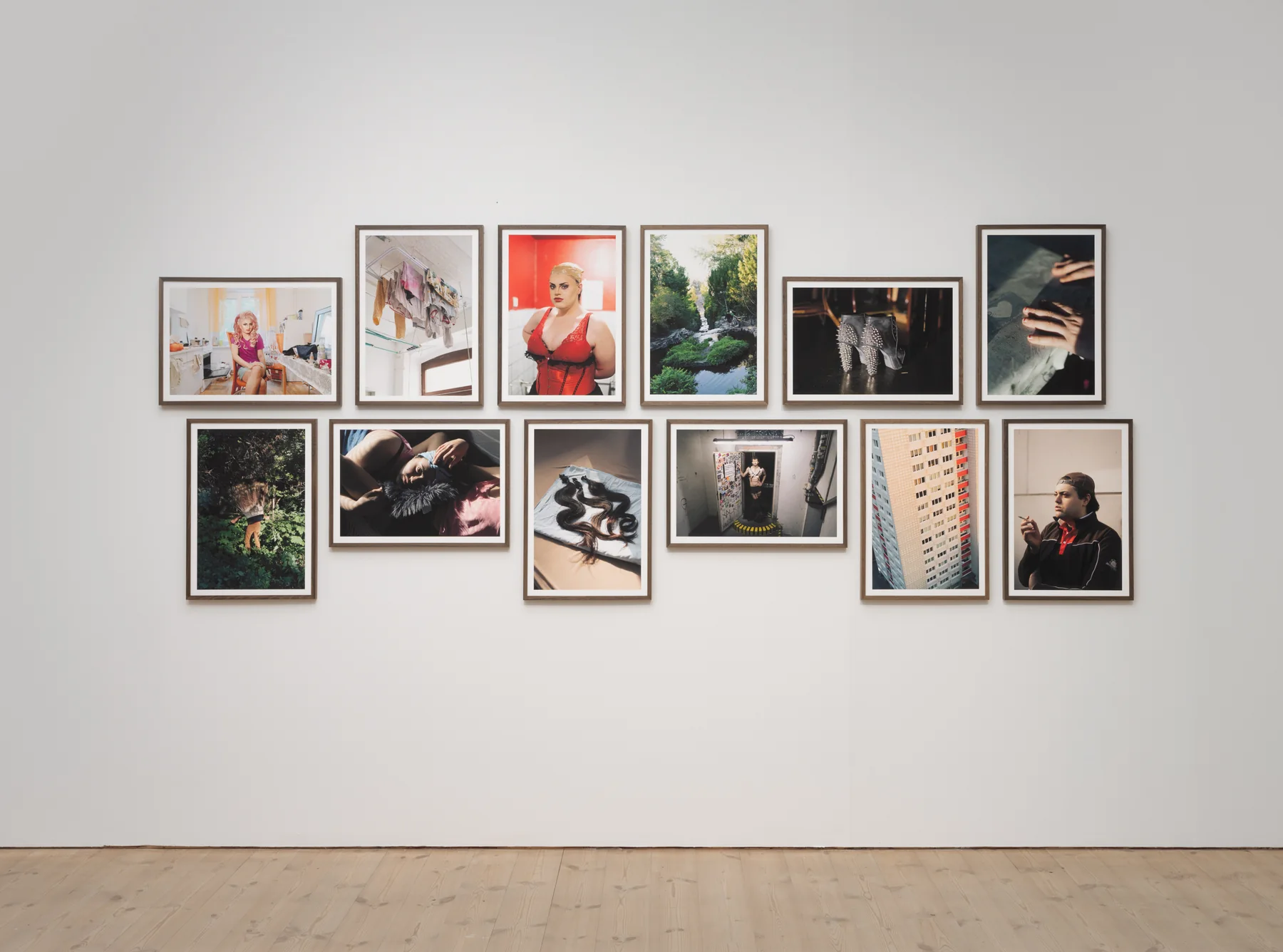 Installation view: a wide wall of framed photographs hung in a loose grid.
