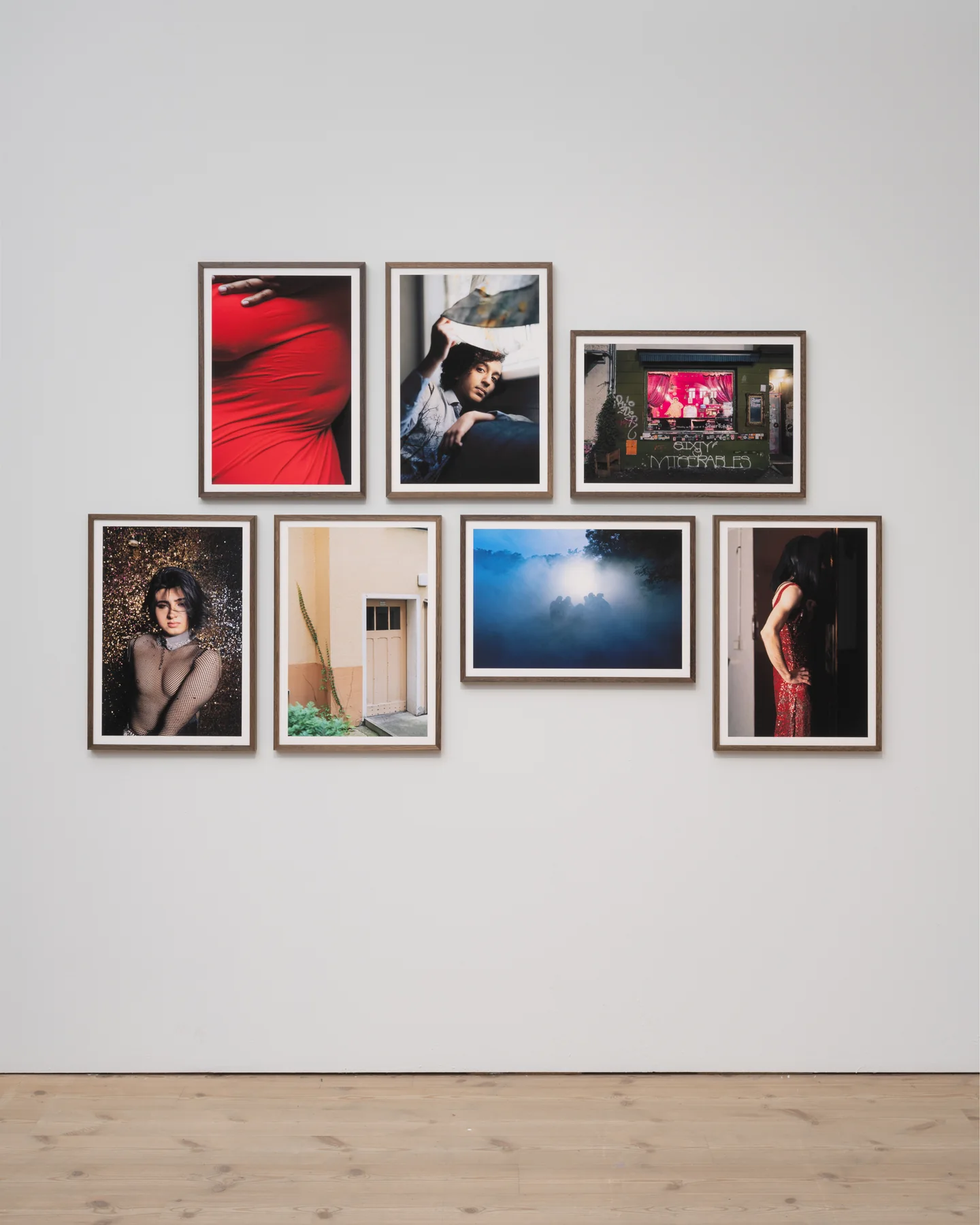 Installation view: a cluster of framed photographs from Come Get Your Honey hung on a white gallery wall.