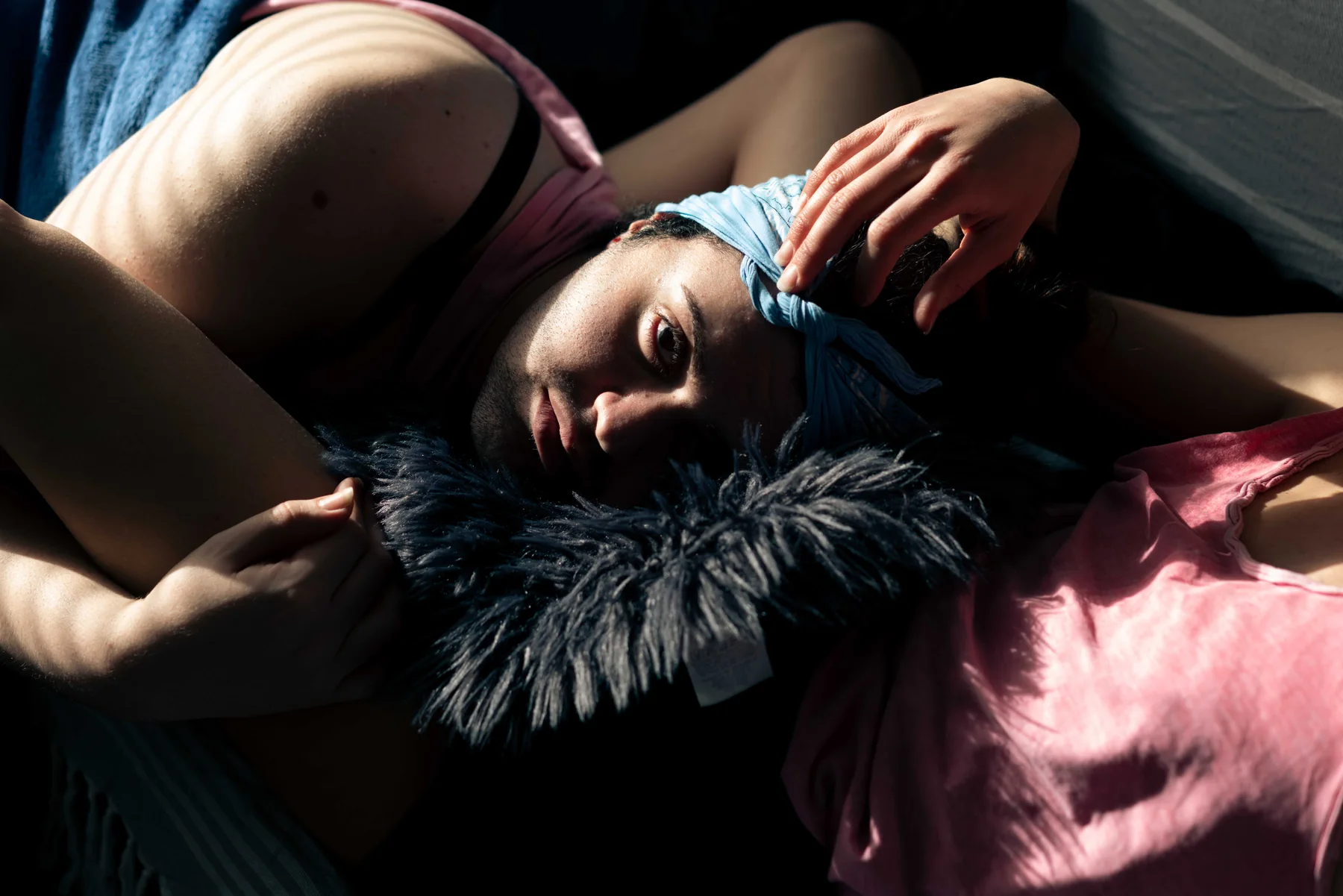 A person lies in soft light wearing a feather boa, the cover photograph of Come Get Your Honey.