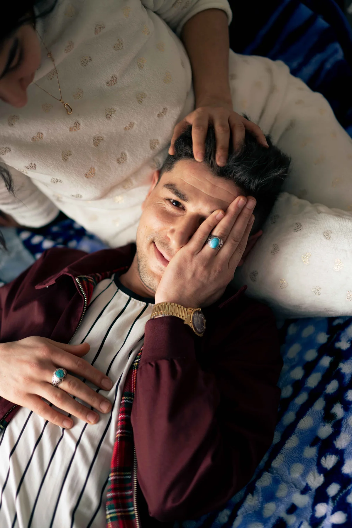 One person lies with their head in another's lap, a hand resting on their hair.